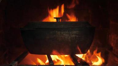 烹饪开放烤箱舌头火焰特写镜头健康的食物概念舌头火焰不断上升的耐热锅准备食物开放空气烤箱健康的生活方式旅行概念